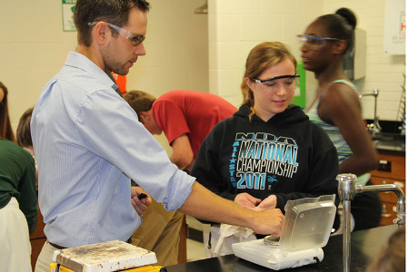Mr. Andy Ribbing helps Katherine Coulter (10) during a physical and chemical changes lab in chemistry, Aug. 21.