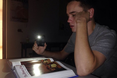 In this photo illustration, Chris Barnett (11) is having major trouble trying to read his textbook without a significant source of light.