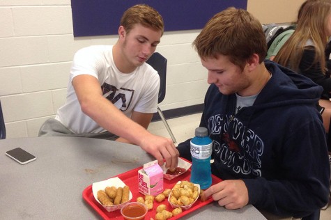 At lunch, Connor McDonald (12) reaches for, Brendan Kloppels (12)  tator tots. 