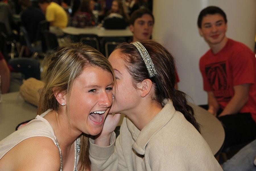 In this photo illustration,  Erin Mocker laughs at a juicy secret told by Taylor Krause (11).