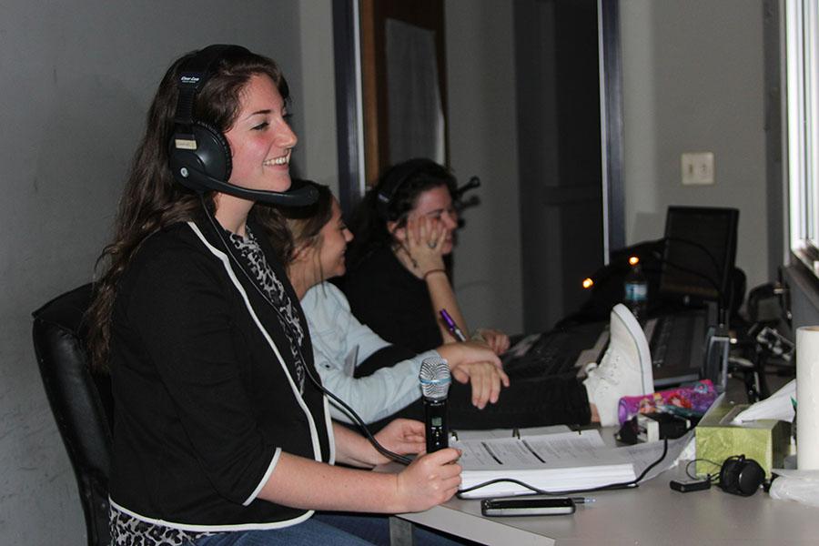 Peyton Ogle, stage manager, sits with microphone in hand with the script waiting to call out cues for the people on stage during practice, Oct. 29.