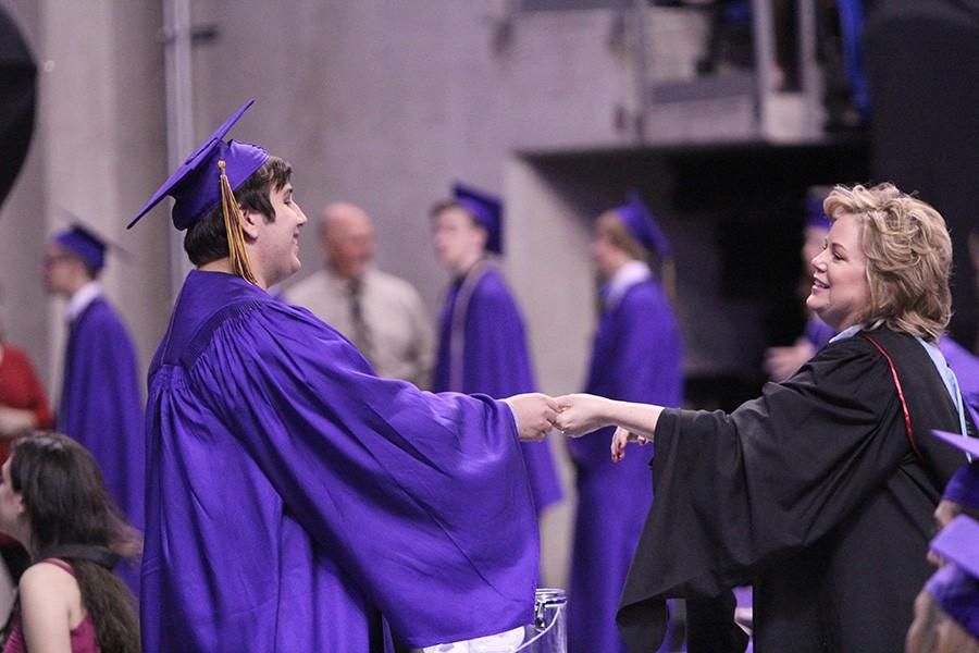 Jon Hoeflinger (12) gives Mrs. Deborah Asher a candle, the senior good-bye present, during her last EHS and her last high school graduation, May 18. Mrs. Asher announced her retirement, May 20.