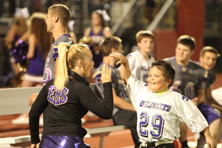 Zoe McCarthy (12) high fives a child who participated in the Friday Nigh Lights event, Sept. 25.