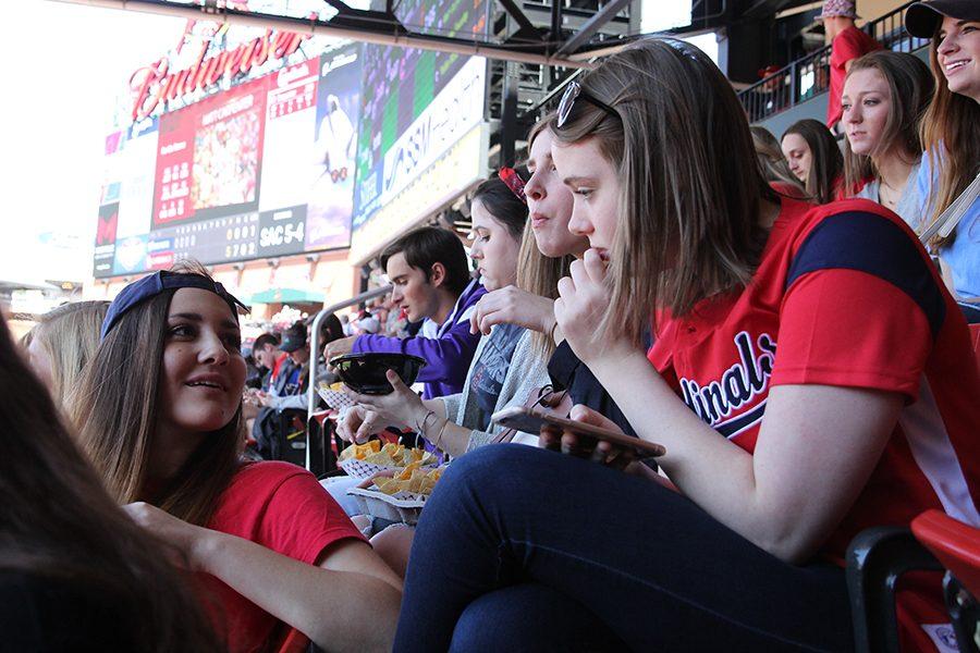 Elizabeth Corbett chats with Cara Peterson during the Cardinals game April 14.