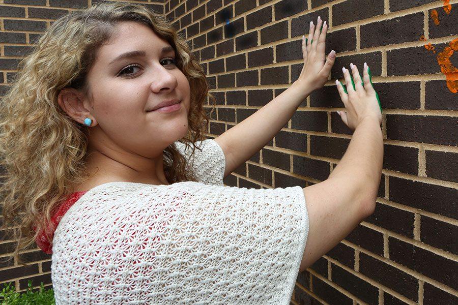 Kendra Coughlin leaves her mark on the wall outside the EHS-hub, May 11.