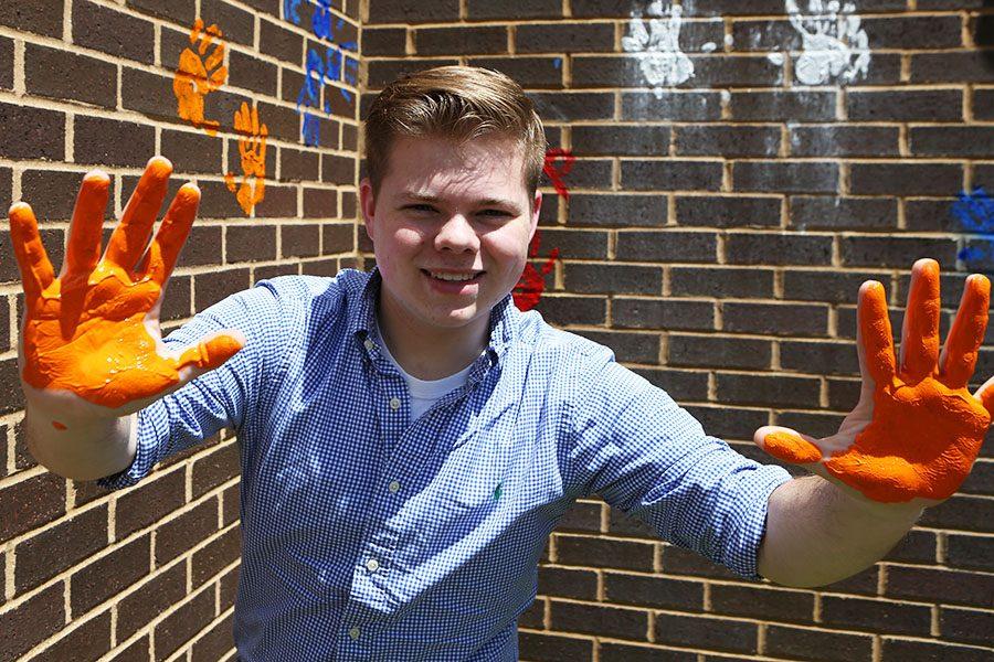 Ryan Bircher leaves his mark on the wall outside the EHS-hub, May 12.