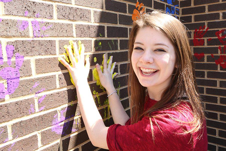 Sarah Wingbermuehle leaves her mark on the wall outside the EHS-hub, May 11.