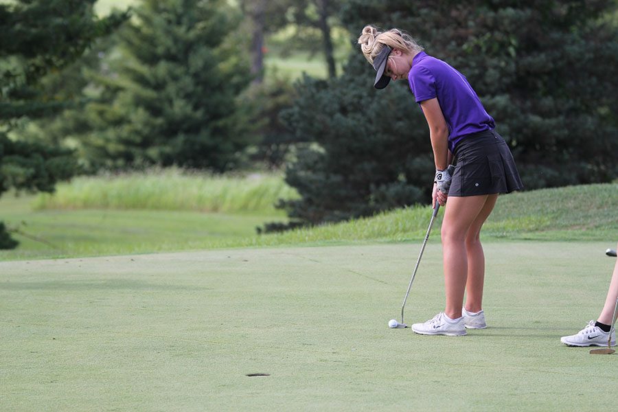 Paige Rhine, varsity golf, prepares to put the ball into the hole during the match against Mehlville at Columbia Golf Club in Columbia, IL, Sept. 7. “Varsity is a lot different than JV, everyone is more of a family and everyone has more experience,” Rhine said. “So it is a lot more fun because everyone does a lot better.” The Wildcats won 171-214.