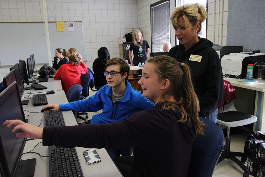Sean Seiter (10) and Megan Mocker (9) describe their work to Mrs. Jennifer Strauser, associate principal, in Mr. Mike Schweickhardt’s Fun App and Game Development class, Oct. 14. Students were making programs. “We were recreating a pong game,” Mocker said. “It’s a really relaxing type of class, but it is also a hard and difficult class.”