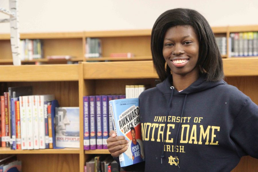 Tia Wilson, QuestBridge scholar, shows off her favorite book and her University of Notre Dame sweatshirt as she comes closer and closer to college. This time next year shell be a member of the Fighting Irish.