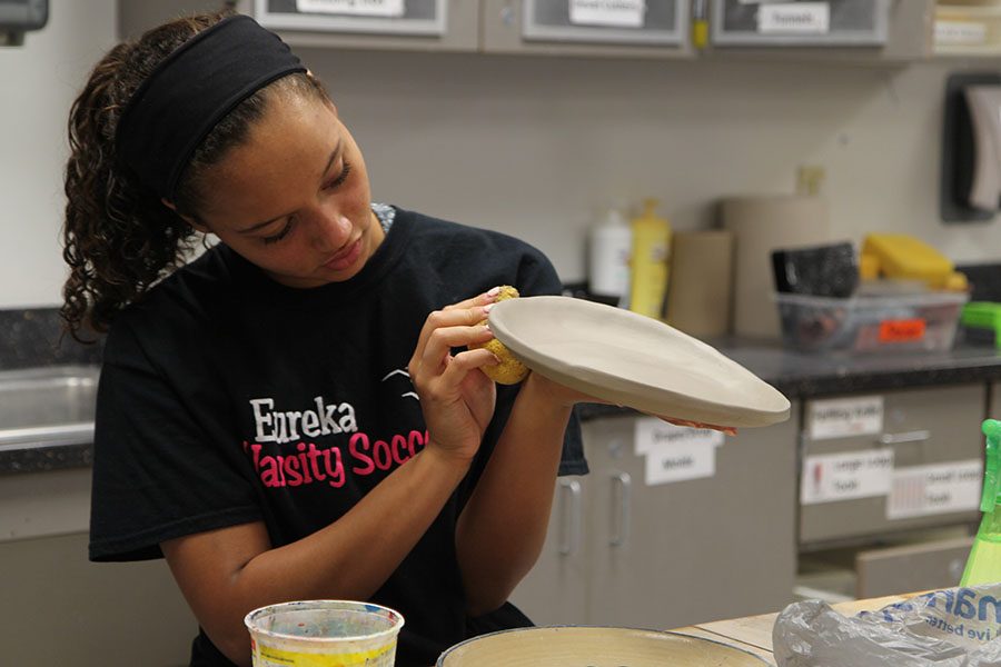 Home and school align as Cameron Robinson (11) smoothes the edges of the plate she is making for her grandpa during Kristina Davis’ first hour Ceramics 2 class, April 18. “I have always loved art and I liked the idea that we get to make whatever we wanted with this project. I ended up wanting to make something for my grandparents,” Robinson said. “My grandpa [David Gentry] is in the hospital, so I wanted to make something to make him happier.”