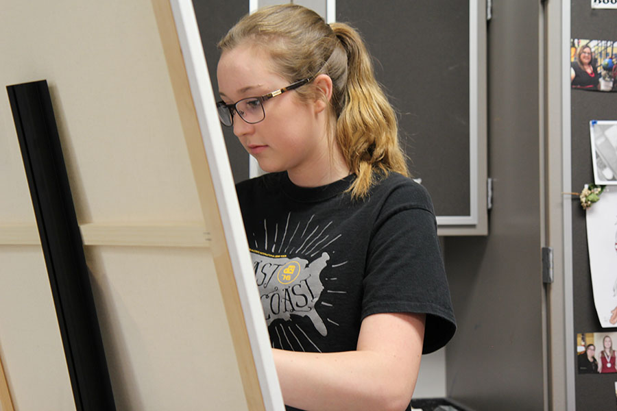 Her canvas on its easel, Courtney St John (11) paints the Chicago skyline during Jessica Esfahani’s first hour Painting 1class, April 25. “I enjoy art and painting,” St John said. “I like that you can be creative and just do what you want to do.”
