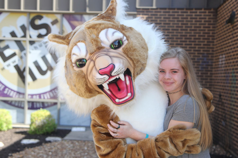 Madison Eble stands in the arms of Wilson the Wildcat as a senior at EHS one last time.