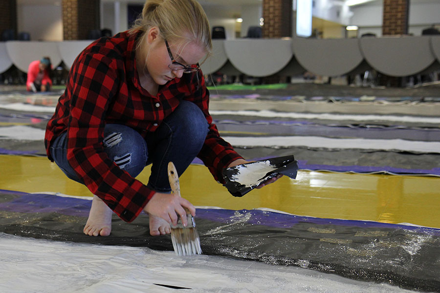 Keridan Gossrau (10) from Student Council paints decorations for the sophomore class wall for Homecoming, Oct. 2. 