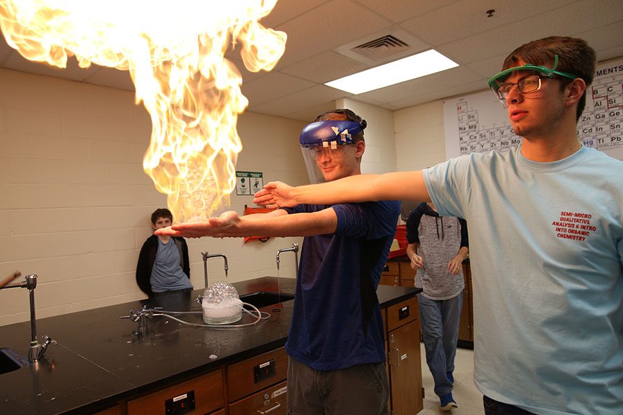 Soap burning in his hands, Clayton Dial (10) holds a ball of fire to celebrate Mole Day in Jonathan Langebacher’s second hour Chemistry class while Tyler Rhoads (12) holds his arms down so he doesn’t burn himself, Oct. 24. “It was fun,” Dial said. “You saw the fire growing in your hands. It was something you don’t do often. I wasn’t nervous. I play with fire so it is something I was used to. I like to see all the chemical reactions in fire and watching things burn.”