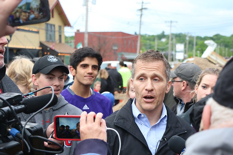 The+media+and+volunteers+surrounding+them%2C+Nick+Cunningham+and+Alec+Holloway+%2812%29+listen+to+Governor+Eric+Greitens%2C+talk++about+the+cleanup+of+the+second+historic+flood+in+Eureka%2C+May+2.+