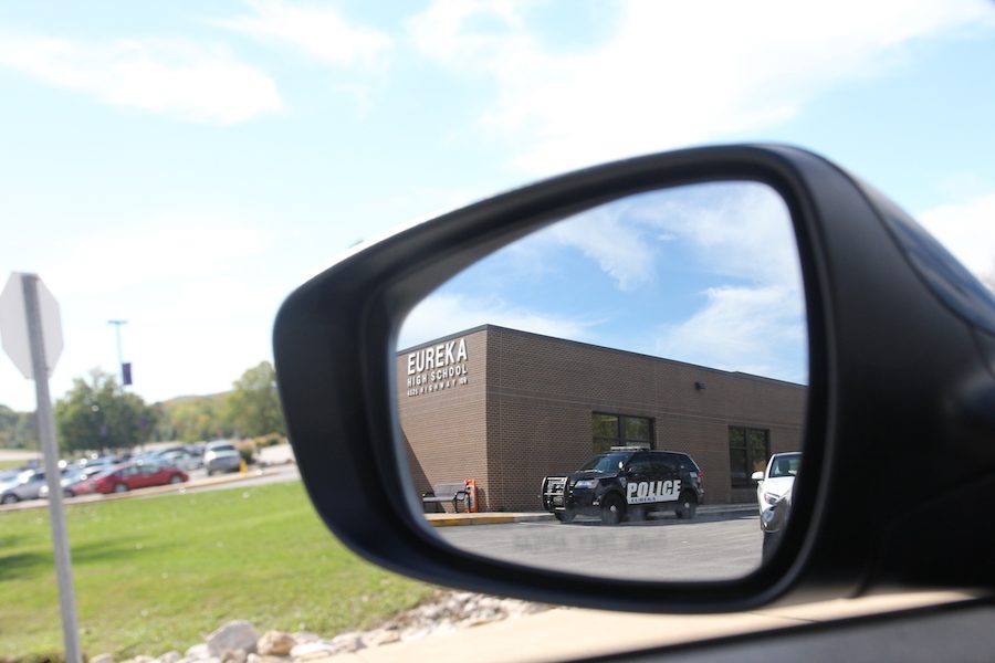 Reflection in sight, the drive up to school is shown through a rearview mirror, Oct. 17. 