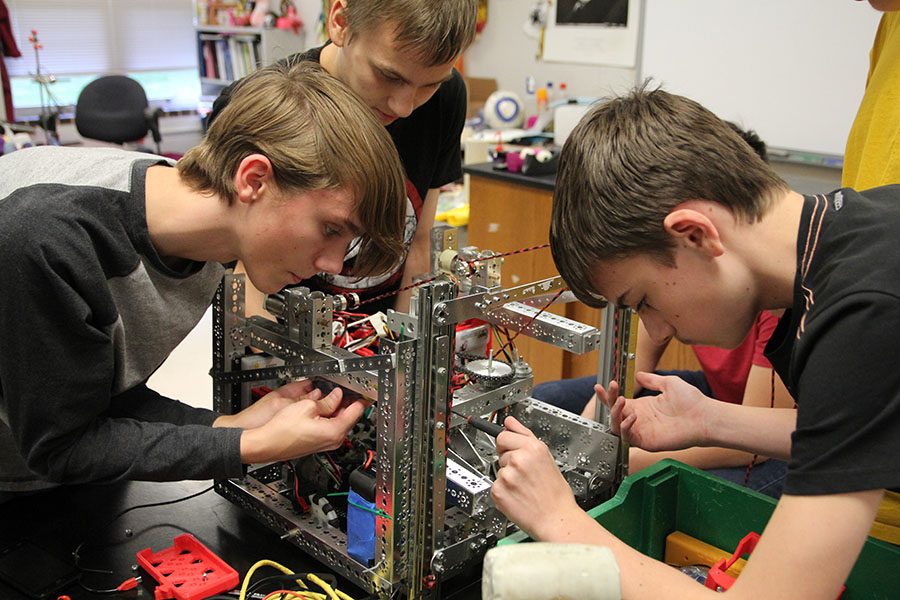 Team robot forming, Anton Fleming (10), William Shulz and Kevin Kwiatkowski (9) attach pieces of where the claw will go at the robotics meeting, Nov. 29. “I like robotics because it is a challenge and you can be creative and come up with new things,” Fleming said. “It is fun because you are not restricted to one thing. You can go any direction you want.”