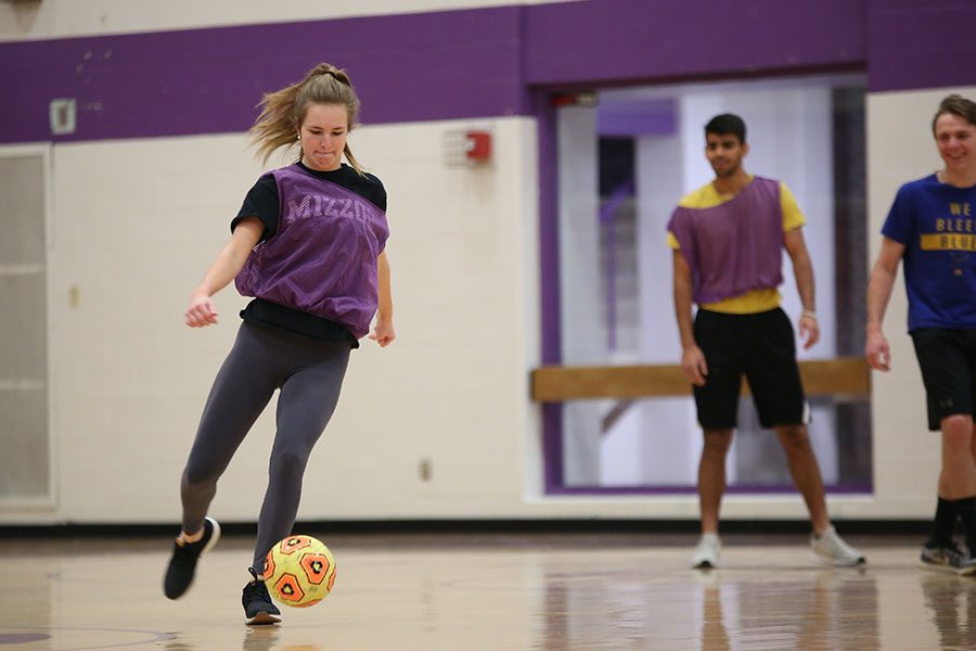 Cold weather forcing the class inside, Kay Satterthwaite (10) dribbles to score a goal in Ralph Gianino’s first hour Team Sports C class, Jan. 12. “I like how small my class is,” Satterthwaite said. “We all know each other, and we have fun together. When you are on your team, everyone is included. In a lot of team sports classes, many students are just sitting around and not participating, but in our class everyone plays and it gets competitive. I would rather play volleyball because I used to play, but the other sports are fun.”
