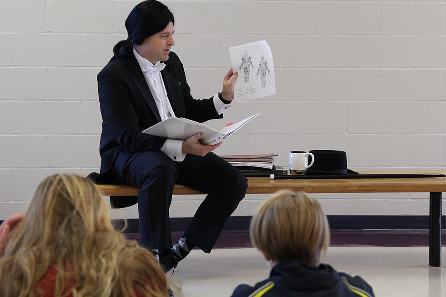 Explaining the human muscular system, Chadd Lamason sports a tuxedo and accompanying wig for winning the Dress like a PE teacher fundraiser, Dec. 15, 2017.