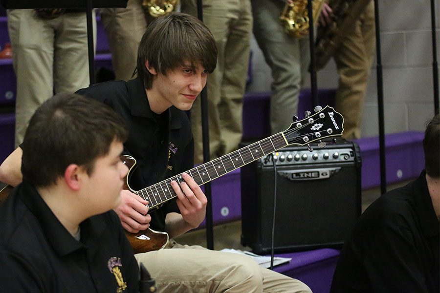 Solo opportunity, Benjamin Tule, guitar, performs “You can call me Al” by Paul Simon at the boys varsity basketball game, Feb. 8. “I havent played that in a while, so I made some mistakes, but it was alright,” Tule said. “Performing at basketball games isn’t the same experience as playing at the football games. The football games are more exciting because of the crowd there is larger, but these games are okay, too.”