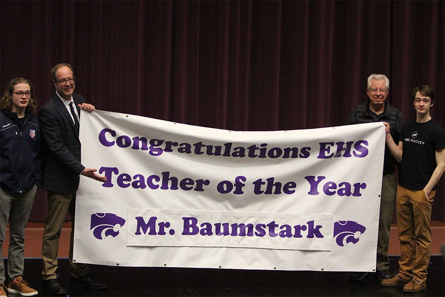 Teacher of the year announced, Walt and Gary Baumstark Jr., winner, poses with Gary Sr. and Eli Baumstark at the ceremony to honor the title, Feb. 26. “I was very humbled and honored to receive such an honor,” Baumstark said. “To be recognized by my peers and so many teachers that I have long respected and looked up to-- that they would see fit to honor me--it is one of the greatest accomplishments of my professional career. Having my family around me was a nice surprise. I wasn't expecting them to come. Apparently they had known about it for about a week but kept it from me. Sharing that recognition was nice. My classes we're all great. Everyone was super excited. I even had students who are not currently my students coming by my class and congratulating me.” 