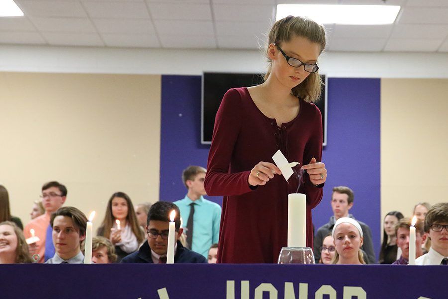 Anna Massey (10) lights her candle during the National Honor Society induction, April 23. “It felt good,” Massey said. “It felt like I was going to be a part of something that was going to help better the society. I always wanted to help people and NHS will only help me do that. I enjoyed the ceremony because I got to see all my friends come together for something.” 