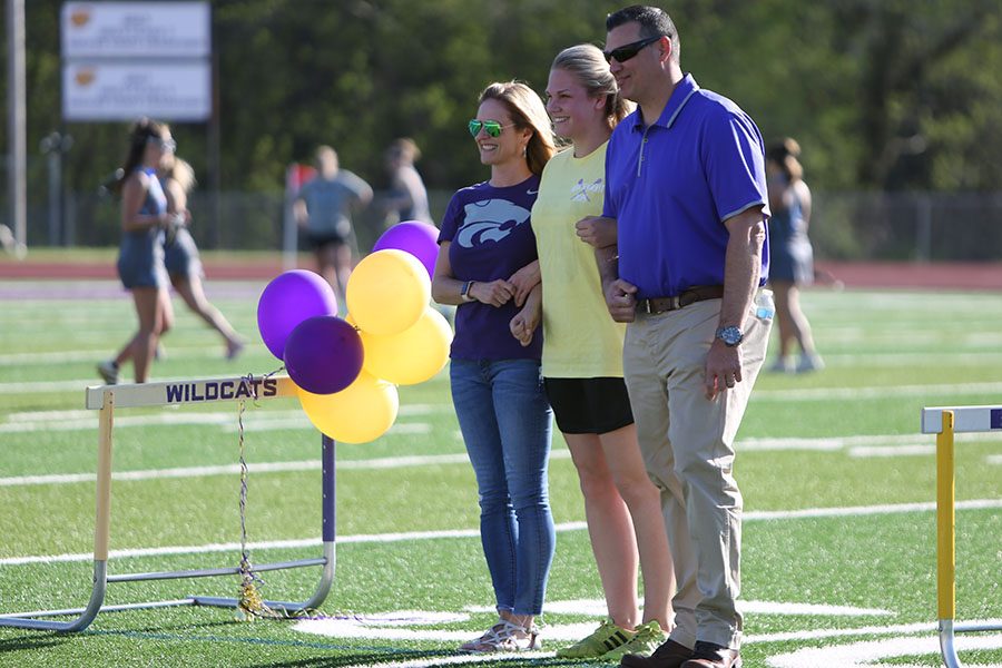 Season coming to an end, Lori Watson, host mother, walks alongside Magali Hermans (German exchange student) and Ryan Watson, host father, during the girls varsity lacrosse senior night, April 30. “I really love to be with the girls on the field,” Hermans said. “I love being able to cheer for them and support them. I love being a part of this team. Senior night was awesome. They all support me. The whole team cheered for me as I walked across the field. It was special. I love my host parents, too. They have supported me this whole year just like a family.”