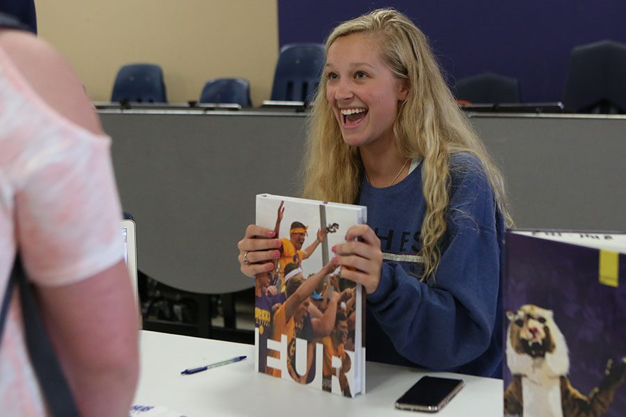2018 Yearbook in her hands, Jordyn Dixon, Eurekana editor-in-chief, talks to freshmen during the freshman activities fair in the Commons, Sept. 10. “It was nice seeing young, new faces eager to get involved in school,” Dixon said. “That is really hard, especially when youre a freshman. I remember when I went to the freshmen activities fair, I didn’t know what I wanted to be involved in. It is nice to see it all displayed. It was a good platform for the students to see everything Eureka offers. A lot of people were really surprised that it was just one staff that creates the whole entire yearbook and that we do it in one year and that it is a class. The freshmen don’t know how big the high school yearbooks are so they were surprised at the size and complexity of the book. As enthusiastic as I am about being on staff, it is different sharing that with someone who you don’t know or who doesn’t know about what we do. You have to explain all the good aspects and see what parts they might like. You try to appeal to them specifically instead of in general.”