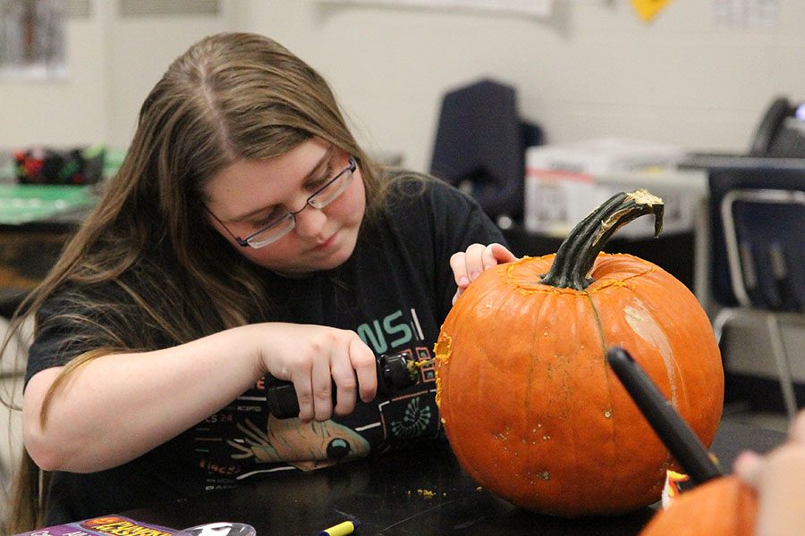 Scary face designed, Anna Reed (10) carves her pumpkin during the Innovative Minds club 
meeting after school, Oct. 18. “We decided to carve pumpkins because it is close to Halloween,” Reed said. “One of the leaders planned it all out. We brought our own pumpkins and Mrs. [Lindsey] Mueller brought us carving tools. We could be creative and design our own face or use the templates the tools provided. I wanted to be creative, so I designed my own scary face to carve.” 