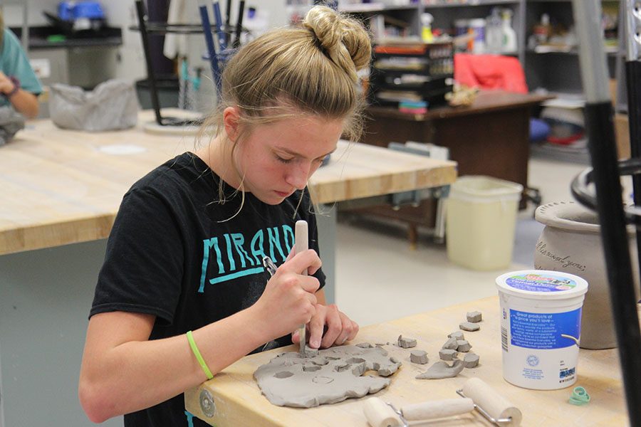 Project almost finished, Bailey Walka (11) adds details to her coil pot after school for Kristina Welch’s sixth hour ceramics class, Oct. 9. “I took ceramics because I needed another art credit and ceramics interested me more than any other art class,” Walka said. “I don’t like to draw and it more 3D than that. It is hands on. I like how you can be creative and make the projects your own. Art is a creative outlet because I can incorporate my faith into it. I can put things that are important to me into my artwork.”