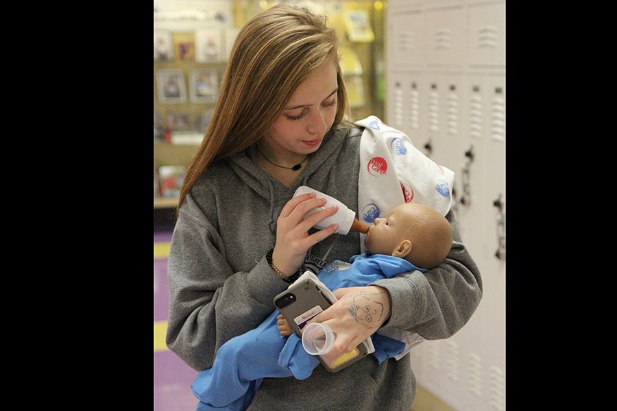 Baby consoled, Emma Miller (10) feeds her electronic baby during Rachel Haywood’s Child Development 1 class, Feb. 7. “I enjoy Child Development because you get to work with the electronic babies,” Miller said. “It is fun to have the feeling of being a mother without the responsibility of a real life child. Whenever I do become a mother, this class will help me prepare to take care of them and raise them to be successful.”Baby consoled, Emma Miller (10) feeds her electronic baby during Rachel Haywood’s Child Development 1 class, Feb. 7. “I enjoy Child Development because you get to work with the electronic babies,” Miller said. “It is fun to have the feeling of being a mother without the responsibility of a real life child. Whenever I do become a mother, this class will help me prepare to take care of them and raise them to be successful.”