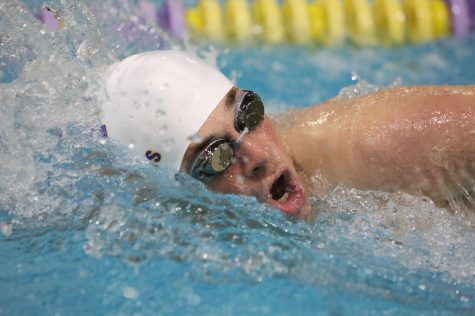 White cap on, BLANK swims in