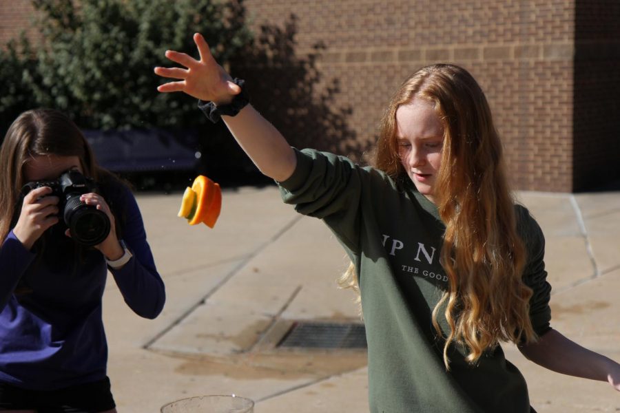 Orange in mid air, Clara Sebourne (11) practices shutter speed skills with fellow classmates during Brent Pearson’s Visual Journalism class, Oct. 9.