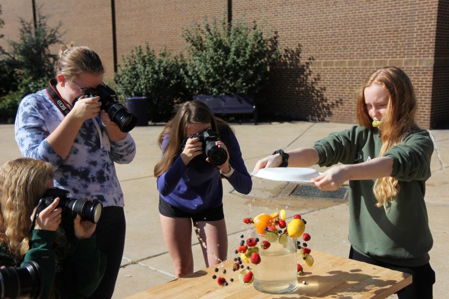 Fruit in mid air, Clara Sebourne (11) practices shutter speed skills with fellow classmates during Brent Pearson’s Visual Journalism class, Oct. 9.