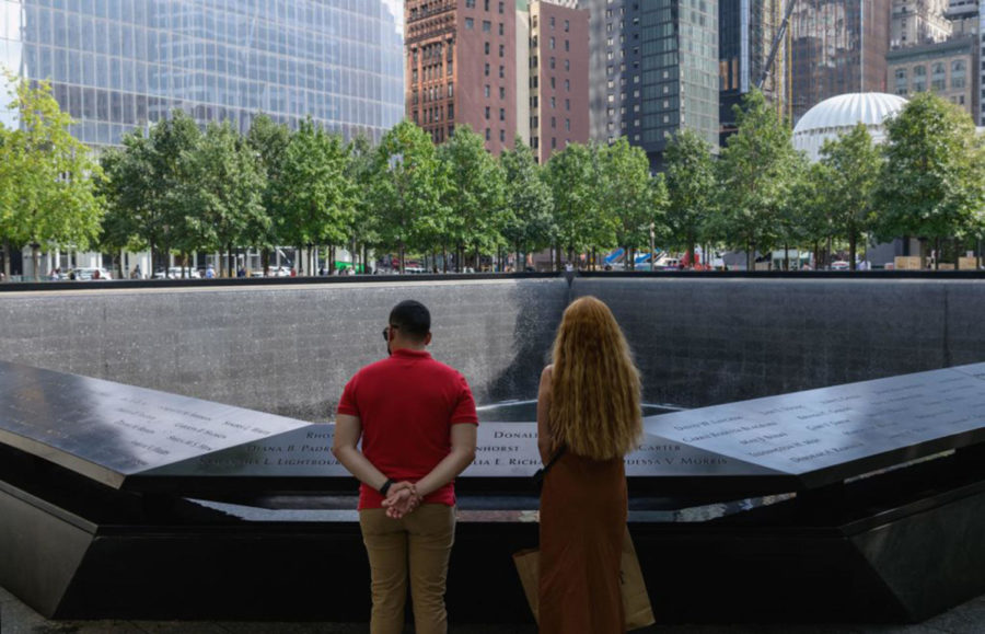 A couple stands before the National September 11 Memorial, marking the site of the south tower at the World Trade Center in New York, on September 8, 2021. - The remains of two more victims of 9/11 have been identified, thanks to advanced DNA technology, New York officials announced on September 7, 2021, just days before the 20th anniversary of the attacks. (Angela Weiss/AFP via Getty Images/TNS)