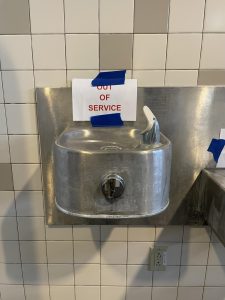 Water fountain in room E129 with “out of service” sign marked by SCI Engineering. 