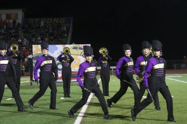 Marching band members perform at football game.