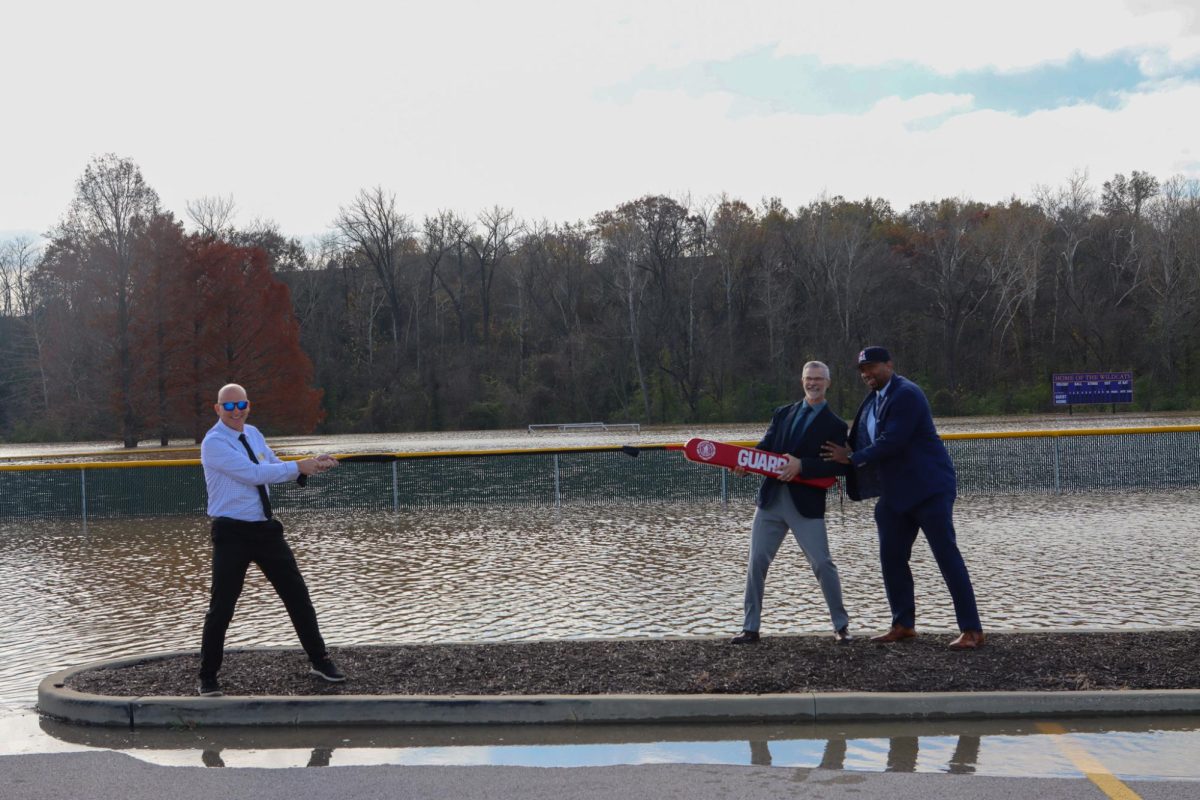 Dr. Corey Sink, Dr. Gary Jansen and Tyrone Dennis examine floodwaters covering the fields and parking lots.