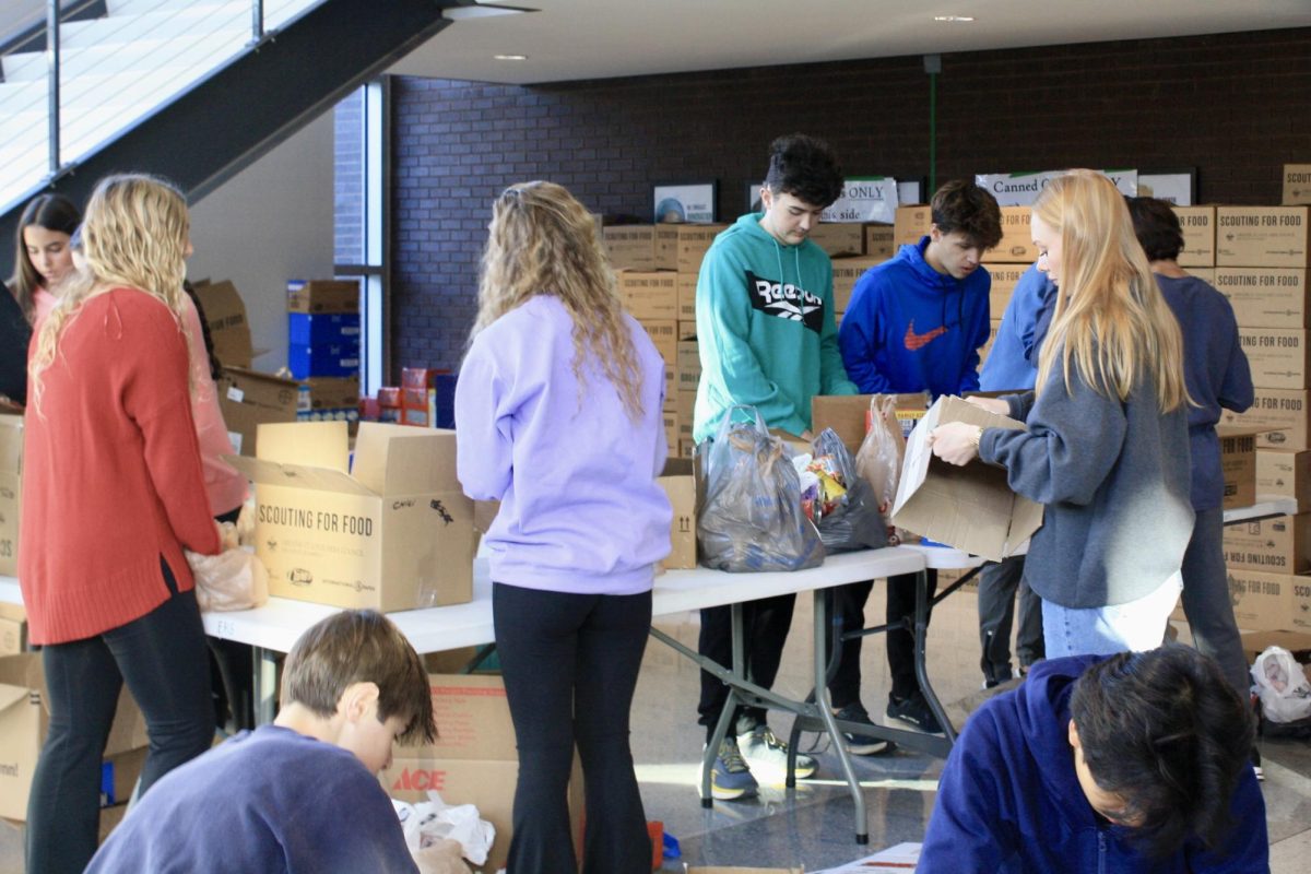 Students box canned foods under the science stairs.