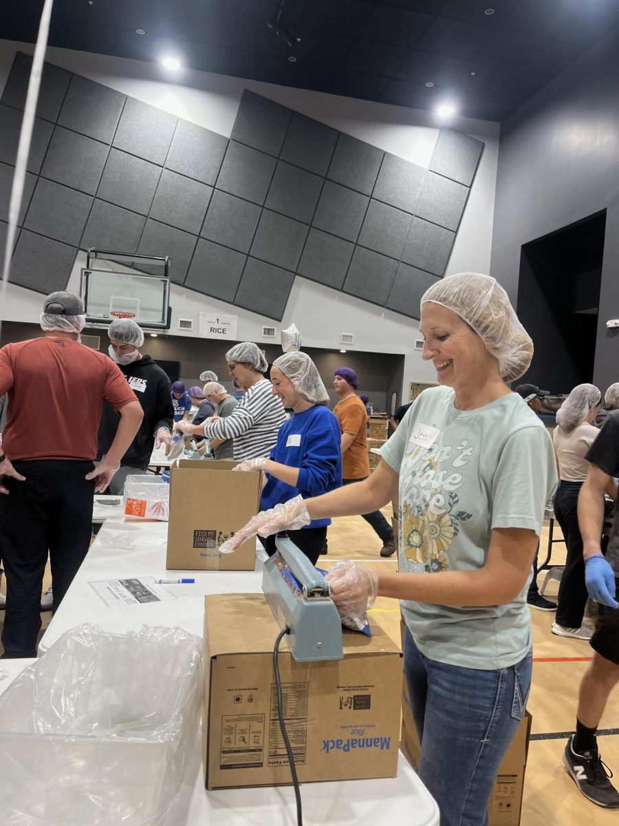 NHS officers and sponsors helping a food packing event for Save My Starving Children.