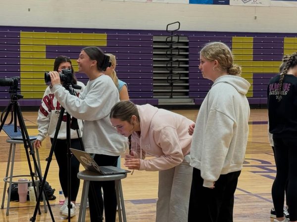 Senior Anna Brotherton (left) collaborates with staff members to photograph after-school clubs for the Eurekana yearbook.